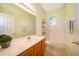 Bright bathroom featuring a single sink vanity, tiled floors, and a shower-tub combo with window at 1173 Valley Creek Run, Winter Park, FL 32792