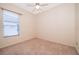 This carpeted bedroom has a ceiling fan and a bright window, offering a simple design at 1173 Valley Creek Run, Winter Park, FL 32792