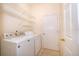 This laundry room includes a washer, dryer, and shelving for optimal storage and convenience at 1173 Valley Creek Run, Winter Park, FL 32792