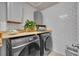 Efficient laundry room with gray appliances, subway tile, and wood countertop at 1191 Honey Blossom Dr # D, Orlando, FL 32824