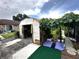 Exterior view of shed in backyard garden with adjacent plants and yoga mat at 12207 Florida Woods Ln, Orlando, FL 32824