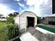 Exterior view of white shed in backyard garden at 12207 Florida Woods Ln, Orlando, FL 32824