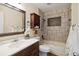 Cozy bathroom features a tiled shower-tub, decorative niche, and vanity storage at 14157 Louisville Ct, Orlando, FL 32826