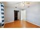 Bright bedroom with hardwood floors, ceiling fan, closet and doorway to the bathroom at 14157 Louisville Ct, Orlando, FL 32826