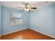 Bedroom featuring light blue walls, hardwood floors, and a window with blinds at 14157 Louisville Ct, Orlando, FL 32826