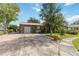 Home exterior featuring brick accents, metal roof, and a paved driveway at 14157 Louisville Ct, Orlando, FL 32826