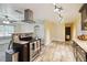 Bright kitchen boasting wood-look tile floors, track lighting, and modern stainless vent hood at 14157 Louisville Ct, Orlando, FL 32826