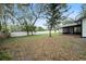 Spacious backyard featuring a white privacy fence, mature trees, and a screened-in porch at 1523 N Beach St, Ormond Beach, FL 32174