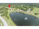 Community aerial view of townhomes by a lake with fountain and green spaces, complemented by mature trees and landscaping at 1534 Barking Deer Cv, Casselberry, FL 32707