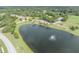 Another community aerial view of townhomes by a lake with fountain and green spaces, complemented by mature trees and landscaping at 1534 Barking Deer Cv, Casselberry, FL 32707