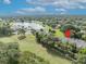 A scenic aerial view of townhomes near a peaceful lake with a fountain, set amidst lush green surroundings at 1534 Barking Deer Cv, Casselberry, FL 32707
