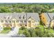 Aerial view of townhomes with yellow siding, well-maintained landscaping, and convenient parking, offering a vibrant community at 1534 Barking Deer Cv, Casselberry, FL 32707
