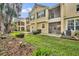 Back exterior view of townhome featuring screened lanais and patios, complemented by green lawn at 1534 Barking Deer Cv, Casselberry, FL 32707
