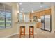 Bright eat-in kitchen features barstool seating, stainless steel refrigerator, and backyard views at 1534 Barking Deer Cv, Casselberry, FL 32707
