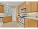 Galley-style kitchen with ample counter space, stainless oven, and backyard views at 1534 Barking Deer Cv, Casselberry, FL 32707
