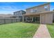 Spacious fenced backyard with a covered patio featuring outdoor seating and a sliding glass door at 15448 Murcott Blossom Blvd, Winter Garden, FL 34787