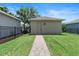 Detached garage with a brick walkway and well-maintained lawn in a fenced backyard at 15448 Murcott Blossom Blvd, Winter Garden, FL 34787