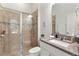 Bathroom featuring a glass-enclosed shower, granite vanity, and decorative mirror at 15448 Murcott Blossom Blvd, Winter Garden, FL 34787