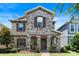 Charming two-story home featuring stone accents, a covered porch, and manicured landscaping at 15448 Murcott Blossom Blvd, Winter Garden, FL 34787