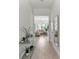 Bright hallway with modern console table leading to the light-filled living room at 15448 Murcott Blossom Blvd, Winter Garden, FL 34787
