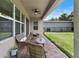 Outdoor patio area with wicker furniture, ceiling fan, and view of a well-maintained lawn at 15448 Murcott Blossom Blvd, Winter Garden, FL 34787