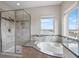 Bright bathroom with a walk-in shower, soaking tub, and scenic window views at 16412 Good Hearth Blvd, Clermont, FL 34711