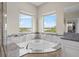 Elegant bathroom features a soaking tub with tile surround and a window view at 16412 Good Hearth Blvd, Clermont, FL 34711