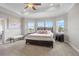 Well-lit bedroom features a tray ceiling, bay windows, and a plush king bed at 16412 Good Hearth Blvd, Clermont, FL 34711