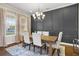 Dining room with paneled accent wall, wood table, six chairs, and a stylish chandelier at 16412 Good Hearth Blvd, Clermont, FL 34711