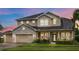 Elegant two-story home with a three-car garage, stone accents, and manicured lawn at 16412 Good Hearth Blvd, Clermont, FL 34711