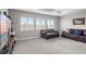 Spacious living room featuring neutral walls, carpet, and bright windows offering natural light at 16412 Good Hearth Blvd, Clermont, FL 34711