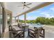 Covered outdoor patio with comfortable seating, offering a view of the pool and lush greenery at 16412 Good Hearth Blvd, Clermont, FL 34711
