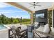 Inviting outdoor patio area with a fireplace, TV, and comfortable seating next to the pool at 16412 Good Hearth Blvd, Clermont, FL 34711
