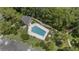 Aerial view of the community pool with nearby buildings and mature trees, providing a serene environment at 165 Durham Pl # 165, Longwood, FL 32779
