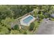 Aerial view of the community pool surrounded by mature trees, lush landscaping and lounge chairs at 165 Durham Pl # 165, Longwood, FL 32779