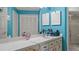Bathroom featuring a vanity with white countertop, turquoise wall, mirrors, and a shower with glass door at 165 Durham Pl # 165, Longwood, FL 32779