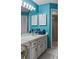 Bathroom featuring a vanity with white countertop, turquoise wall, and mirrors flanked by lights at 165 Durham Pl # 165, Longwood, FL 32779