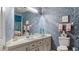 Bathroom with white vanity, patterned wallpaper, decor, and well-lit vanity mirror at 165 Durham Pl # 165, Longwood, FL 32779