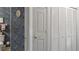 Half bathroom with patterned wallpaper, white fixtures, and shutter doors to storage at 165 Durham Pl # 165, Longwood, FL 32779