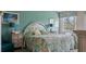 Cozy bedroom with teal accent wall, floral bedding, and bright natural light from a large window at 165 Durham Pl # 165, Longwood, FL 32779