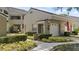 Inviting condo exterior showcasing landscaped garden beds and an attached one-car garage at 165 Durham Pl # 165, Longwood, FL 32779
