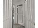 Hallway view featuring white louvered doors and neutral carpeting with an open doorway to another room at 165 Durham Pl # 165, Longwood, FL 32779