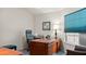 Office space with a large wooden desk, executive chair, window with blinds, and wall decor at 165 Durham Pl # 165, Longwood, FL 32779