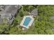Aerial view of a pristine pool with lounge chairs surrounded by lush landscaping in a residential community at 165 Durham Pl # 165, Longwood, FL 32779