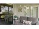 Screened porch with neutral toned couch, floral pillow, and view to the exterior landscape at 165 Durham Pl # 165, Longwood, FL 32779