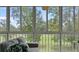 Screened porch with comfortable couch, floral pillow, and views of the natural landscape at 165 Durham Pl # 165, Longwood, FL 32779