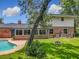 This backyard features an in-ground fire pit, attached sunroom, in-ground pool, and well-kept green grass at 1850 Lakeshore Cir, Longwood, FL 32750