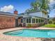 An aerial view of the in-ground pool shows the attached brick sunroom, spacious backyard, and second story of the home at 1850 Lakeshore Cir, Longwood, FL 32750