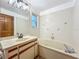 Bathroom with a tub, vanity, toilet, and window providing natural light to the tiled space at 1850 Lakeshore Cir, Longwood, FL 32750