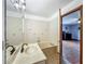 A bathroom showcases a tub, marble countertop vanity, floral tiled walls, and open doorway at 1850 Lakeshore Cir, Longwood, FL 32750